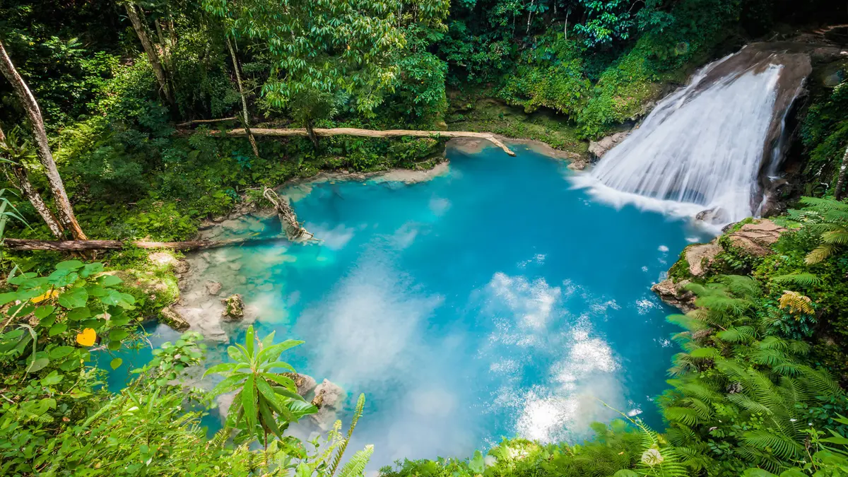 Vibrant blue natural pool and waterfall in Jamaica